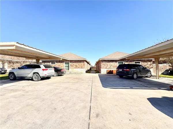 a front view of a building with cars parked