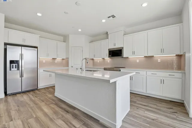a kitchen with white cabinets and stainless steel appliances