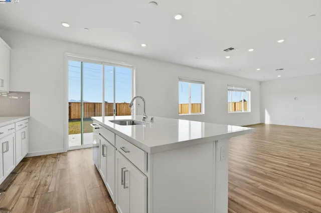 a kitchen with a sink and wooden floor