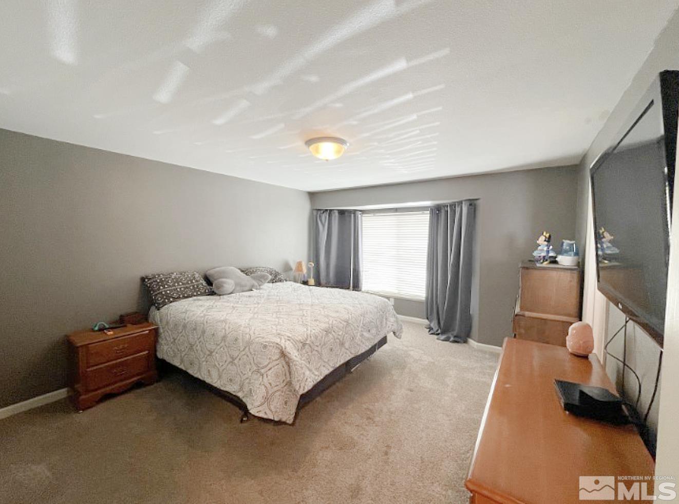 562 Yellow Jacket Road Dayton, NV 89403 - Photo 11 of 27 a spacious bedroom with a bed and a couch