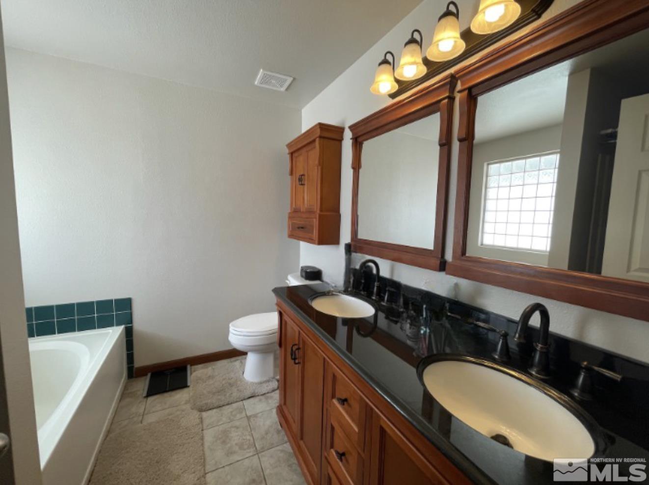 562 Yellow Jacket Road Dayton, NV 89403 - Photo 12 of 27 a bathroom with a double vanity sink and a mirror