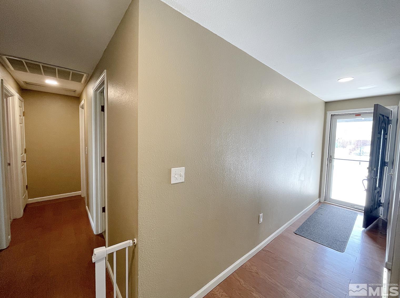 562 Yellow Jacket Road Dayton, NV 89403 - Photo 6 of 27 an empty room with wooden floor and windows