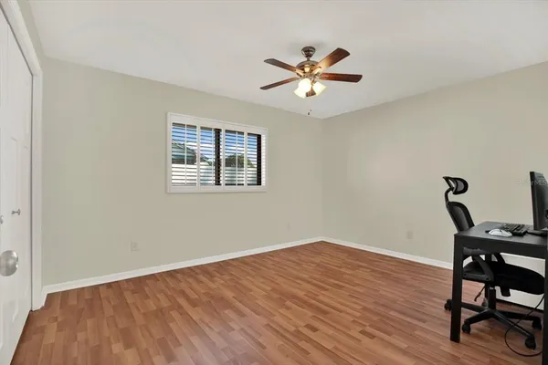 a view of a workspace with wooden floor and a window