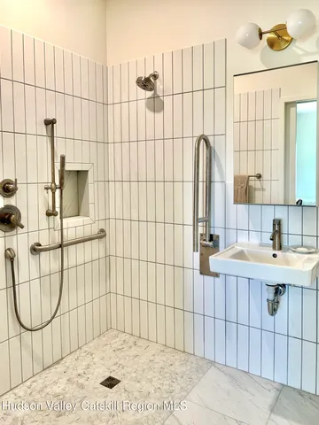 a bathroom with a sink vanity and a shower