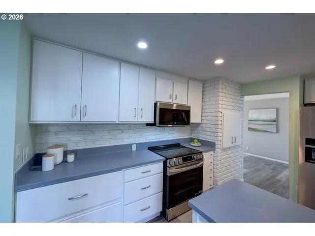 a kitchen with stainless steel appliances granite countertop a refrigerator and a sink