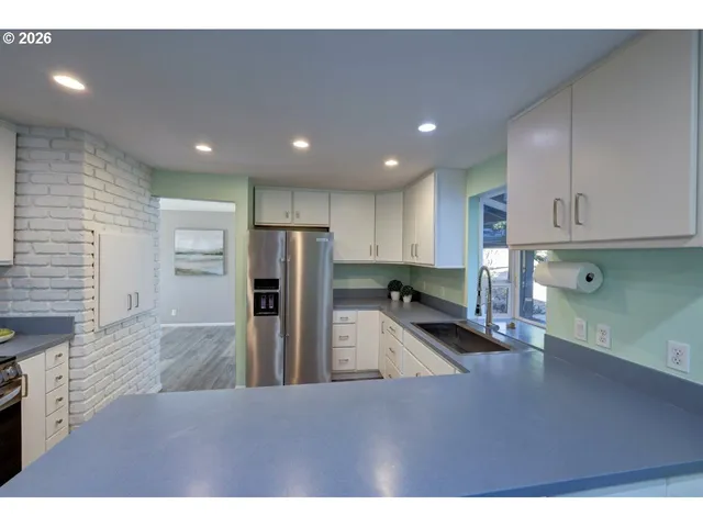 a kitchen with white cabinets and window