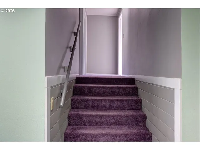 a view of an empty room with closet and windows