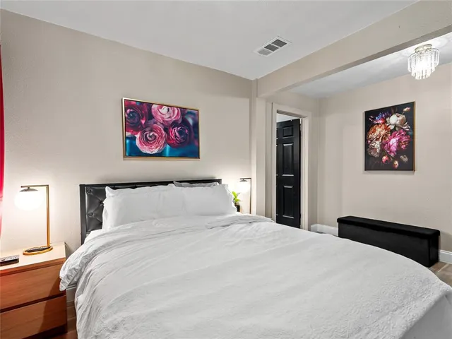a bedroom with a large bed and a painting on the wall