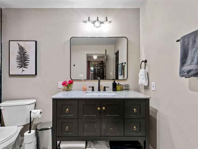 a bathroom with a toilet sink and mirror