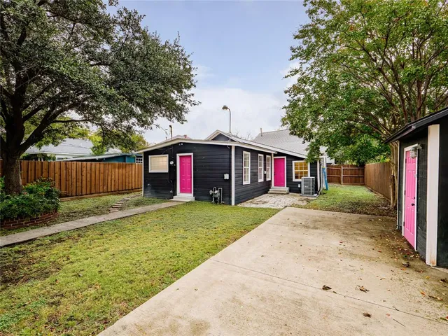 a view of a yard with a house and a large tree