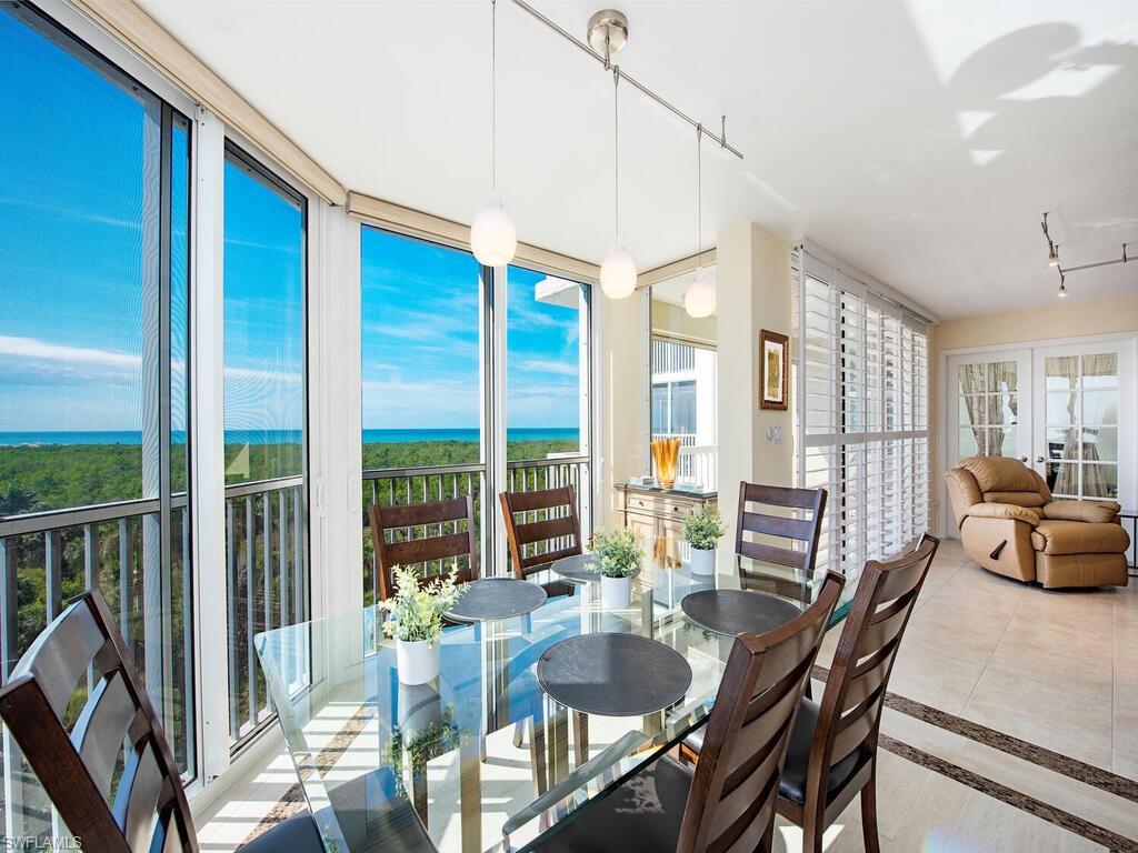a dining room with furniture a chandelier and wooden floor
