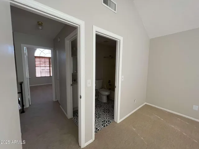 an empty room with a ceiling fan and a window