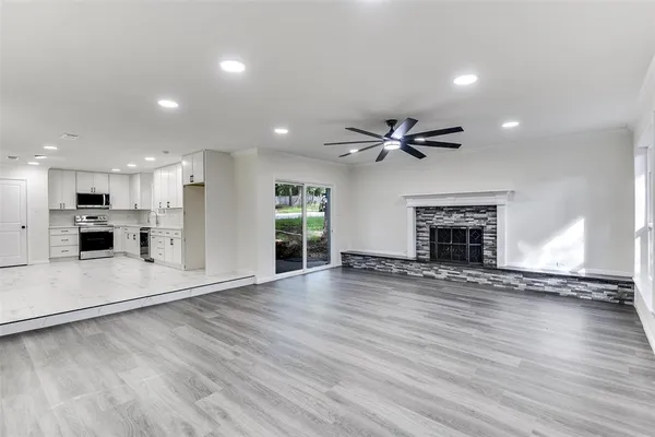 a view of empty room with wooden floor and fireplace