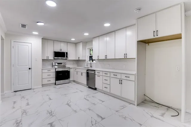 a kitchen with granite countertop cabinets and white stainless steel appliances