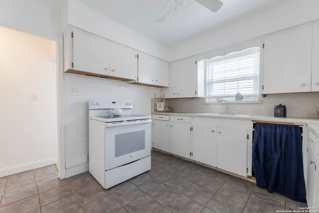 a kitchen with cabinets appliances a sink and a window