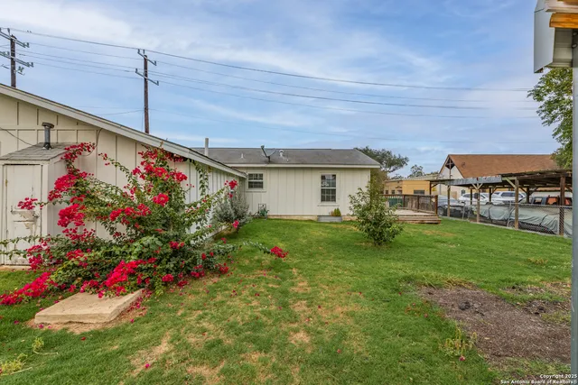a view of a house with a backyard and plants