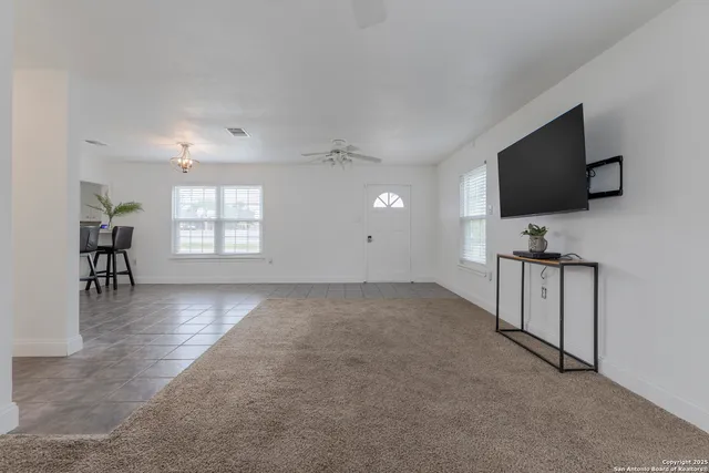 an empty room with windows flat screen tv and windows