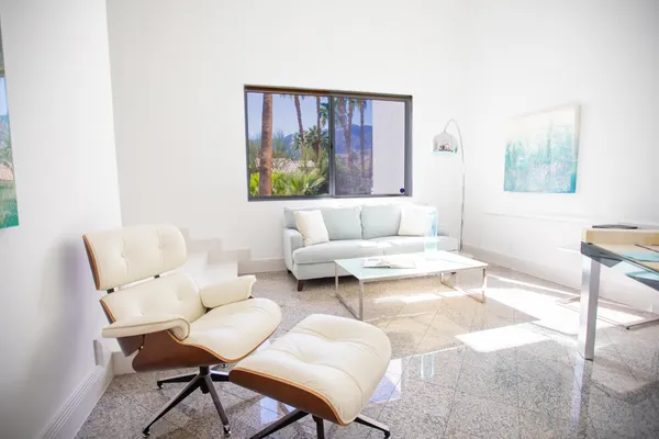 a backyard of a house with fountain table and chairs