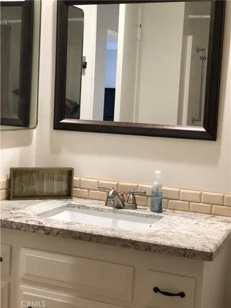 a bathroom with a granite countertop sink and a mirror