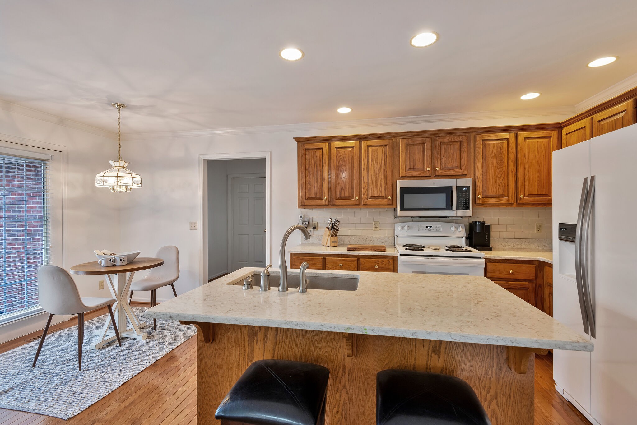 1102 High Lake Drive Dickson, TN 37055 - Photo 15 of 50 a kitchen with stainless steel appliances a table chairs microwave and refrigerator