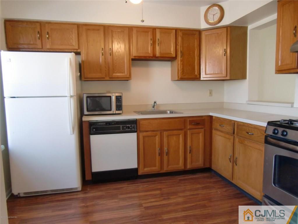 15 Interlaken Court, Unit 8 Freehold, NJ 07728 - Photo 3 of 13 a kitchen with stainless steel appliances a refrigerator stove and sink