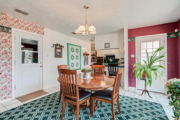 a dining room with furniture a chandelier and window