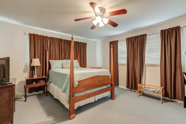 a bed sitting in a spacious bedroom next to a window