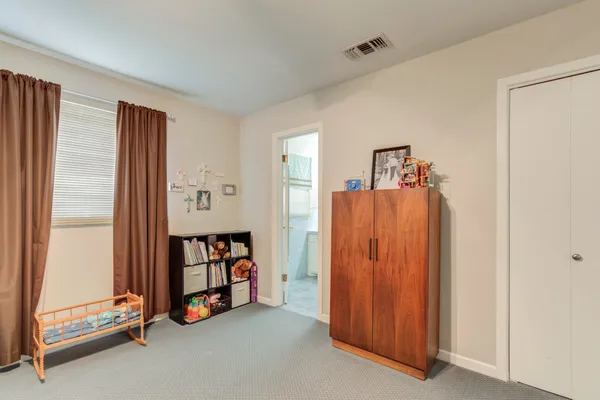 a view of an empty room with window a ceiling fan and front door