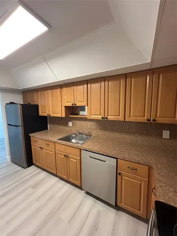 a kitchen with stainless steel appliances granite countertop a stove a sink and a refrigerator