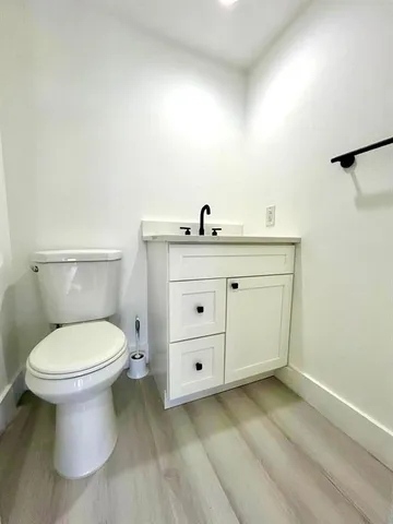 a bathroom with a toilet a sink and mirror