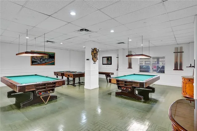 a room with furniture pool table and window