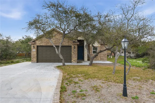 a view of a house with backyard and tree