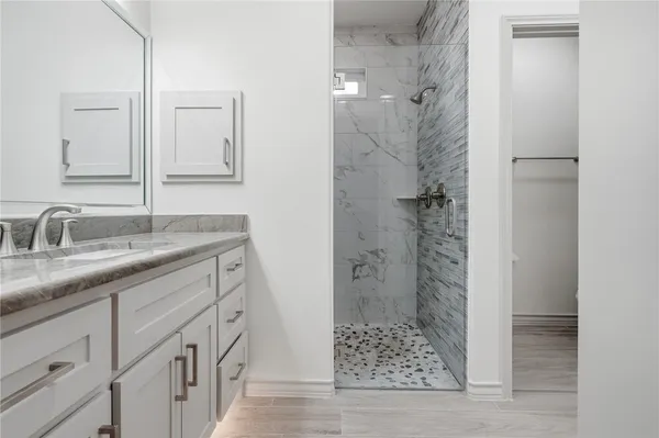 a bathroom with a shower sink and mirror