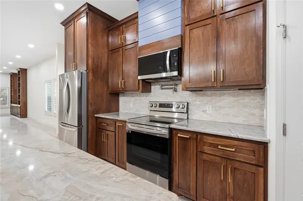 a kitchen with stainless steel appliances granite countertop a stove microwave and refrigerator