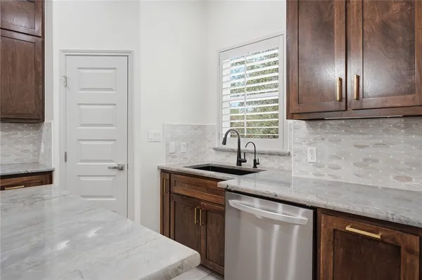 a kitchen with granite countertop stainless steel appliances a sink stove and cabinets