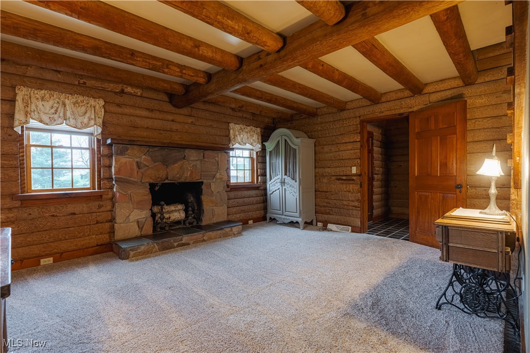 2990 Randolph Road Mogadore, OH 44260 - Photo 17 of 28 Carpeted living room featuring a fireplace, beamed ceiling, and log walls