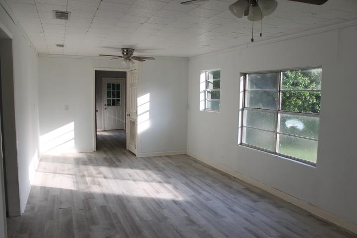 875 Woodrow Street Silsbee, TX 77656 - Photo 9 of 30 an empty room with windows and ceiling fan