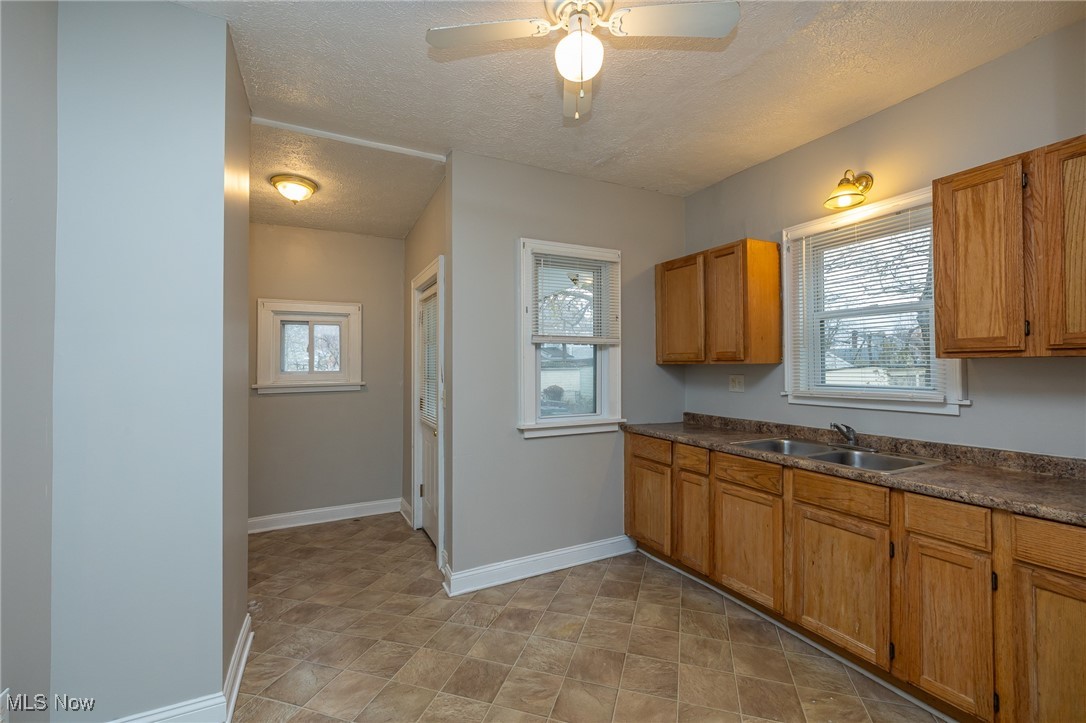 3396 Tullamore Road Cleveland, OH 44118 - Photo 9 of 23 Kitchen featuring dark countertops, a textured ceiling, healthy amount of natural light, and ceiling fan