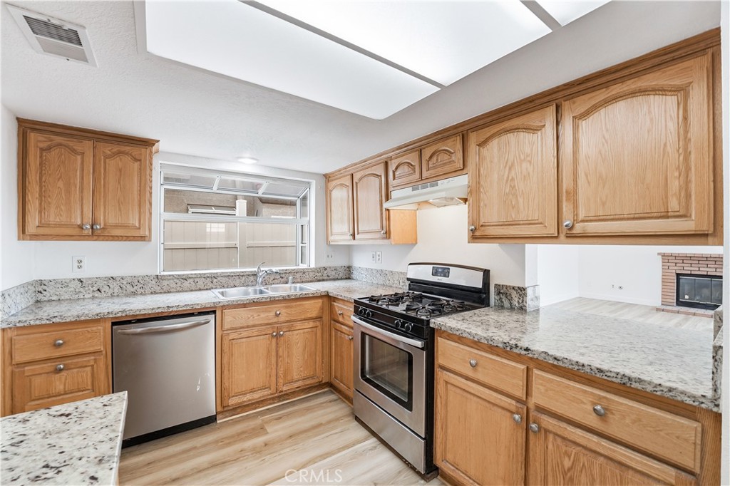 338 Mildred Street Perris, CA 92571 - Photo 11 of 34 a kitchen with granite countertop cabinets stainless steel appliances a sink and a window