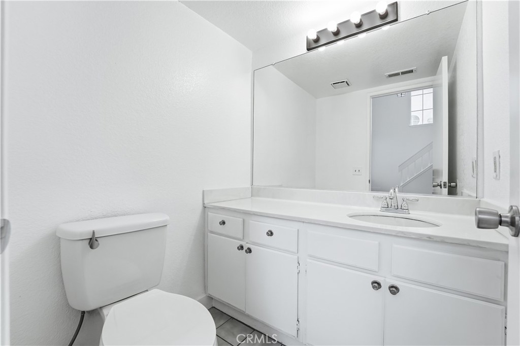 338 Mildred Street Perris, CA 92571 - Photo 13 of 34 a bathroom with a granite countertop toilet sink and mirror