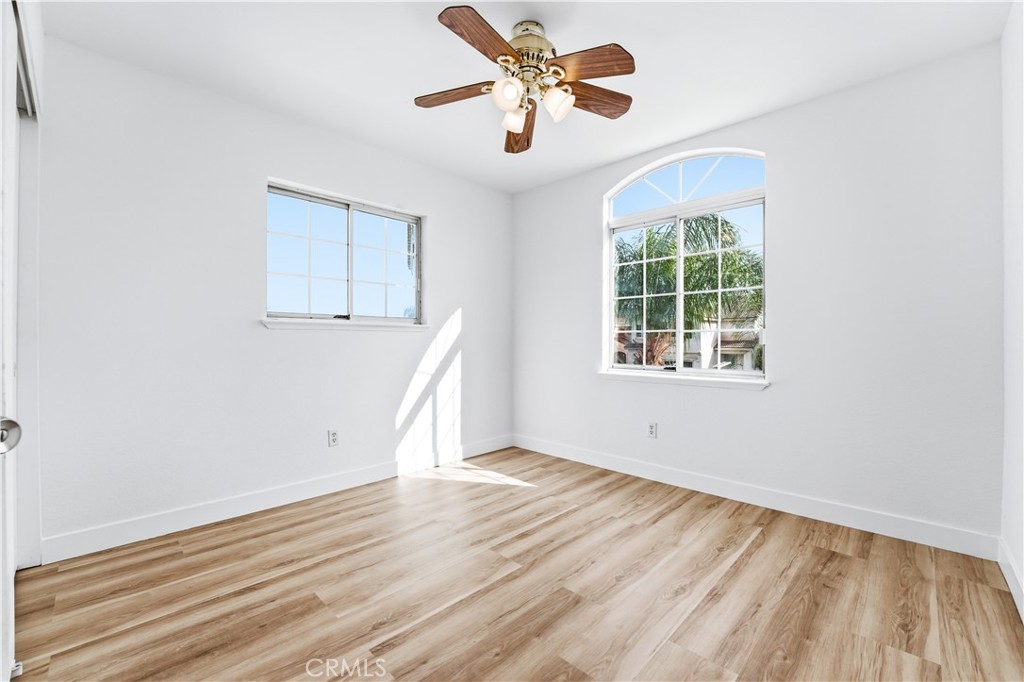 338 Mildred Street Perris, CA 92571 - Photo 22 of 34 an empty room with wooden floor chandelier fan and windows