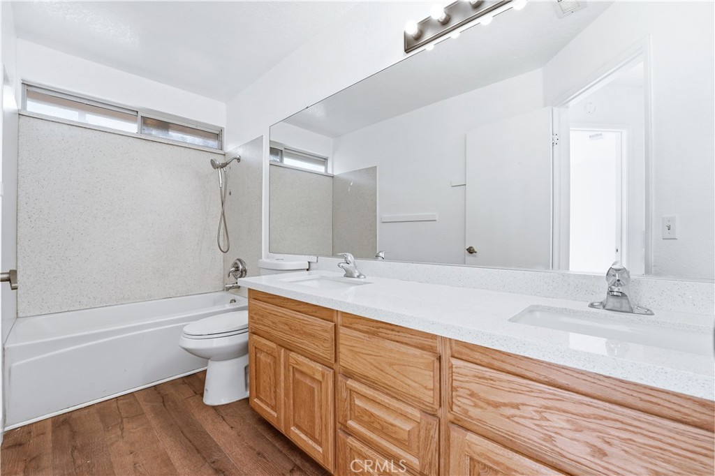 338 Mildred Street Perris, CA 92571 - Photo 23 of 34 a bathroom with a double vanity sink toilet mirror and bathtub