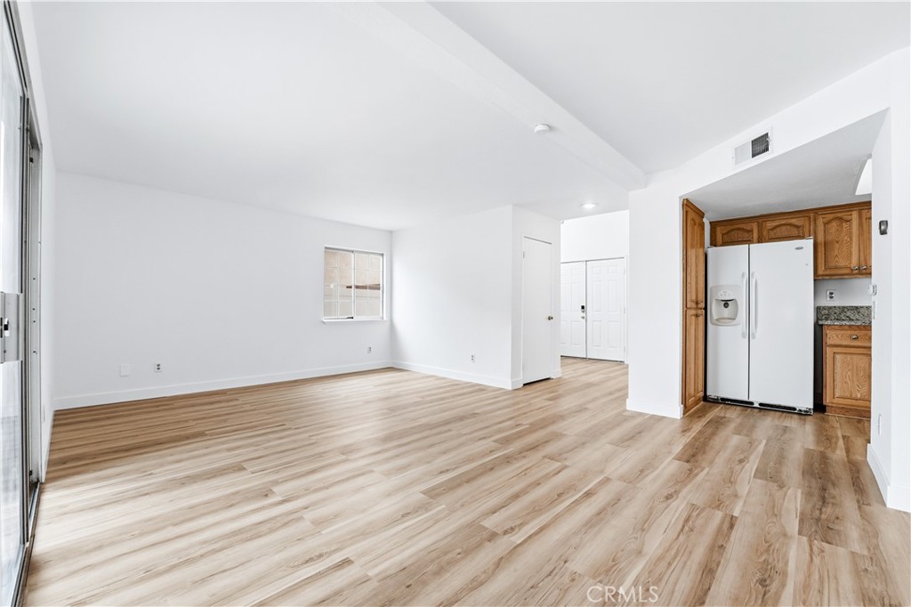 338 Mildred Street Perris, CA 92571 - Photo 6 of 34 a view of empty room with wooden floor and refrigerator