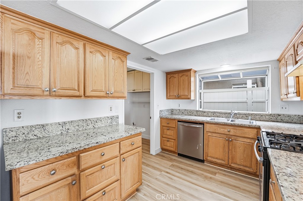 338 Mildred Street Perris, CA 92571 - Photo 10 of 34 a kitchen with granite countertop cabinets stainless steel appliances a sink and a window