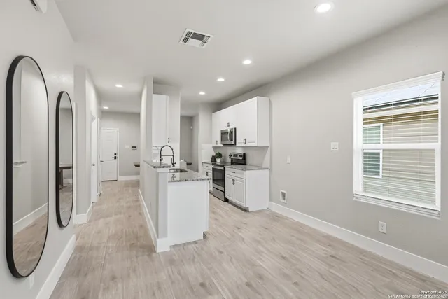 a view of a kitchen with refrigerator and wooden floor