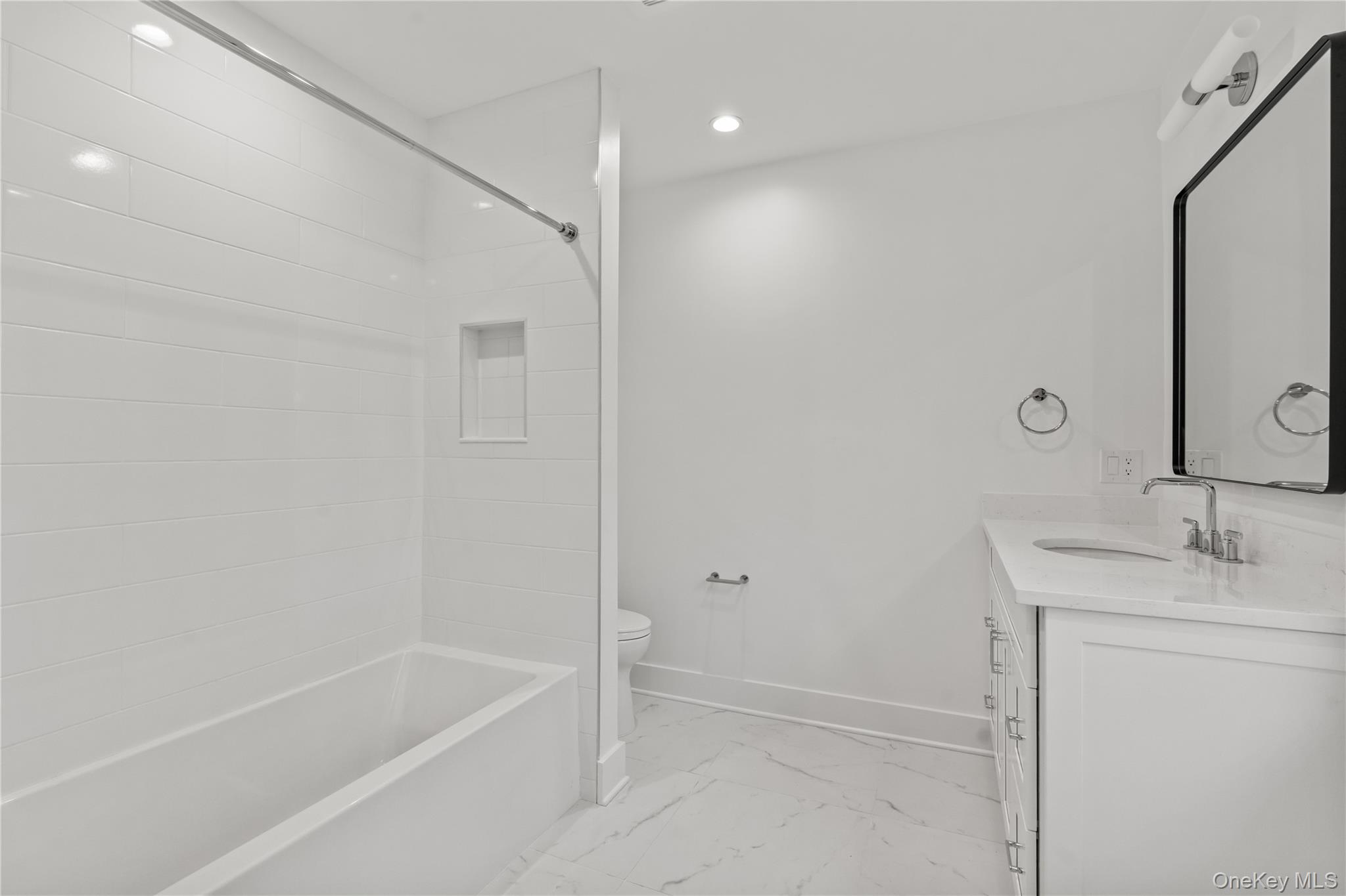 26 Latimer Lane Bronxville, NY 10708 - Photo 26 of 37 a bathroom with a granite countertop sink a mirror and a bathtub