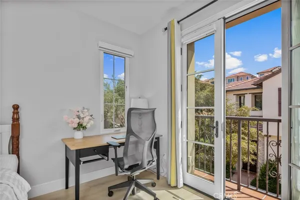 a view of a workspace room with furniture and windows