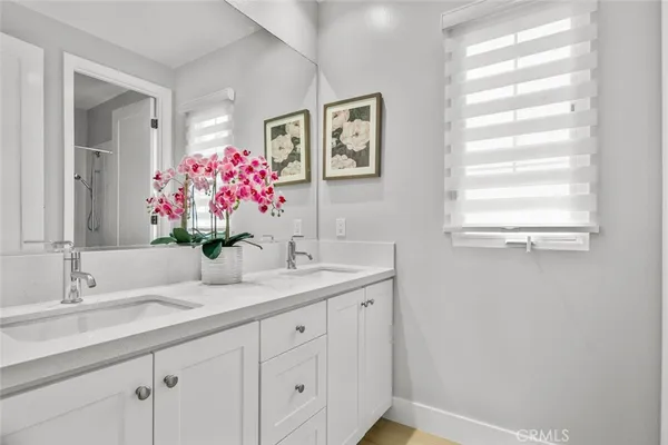 a bathroom with a granite countertop sink mirror and next to a window