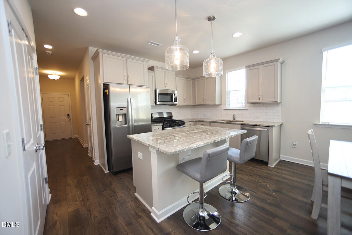 125 Mae Court Roxboro, NC 27573 - Photo 6 of 30 a kitchen with a refrigerator a sink dishwasher a stove and white cabinets with wooden floor
