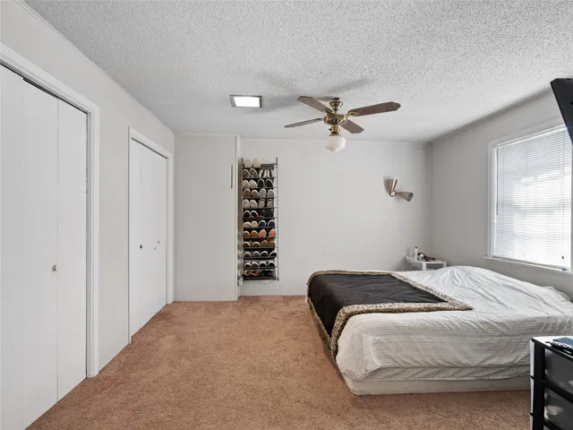 a bedroom with a large bed and a ceiling fan